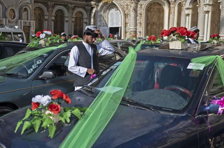  Un novio afgano junto a autos decorados afuera de un salón de bodas en Kabul / Foto: AFP