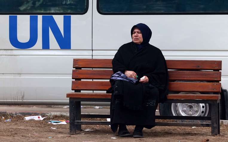 Una mujer palestina espera fuera de una clínica en la Franja de Gaza/AFP