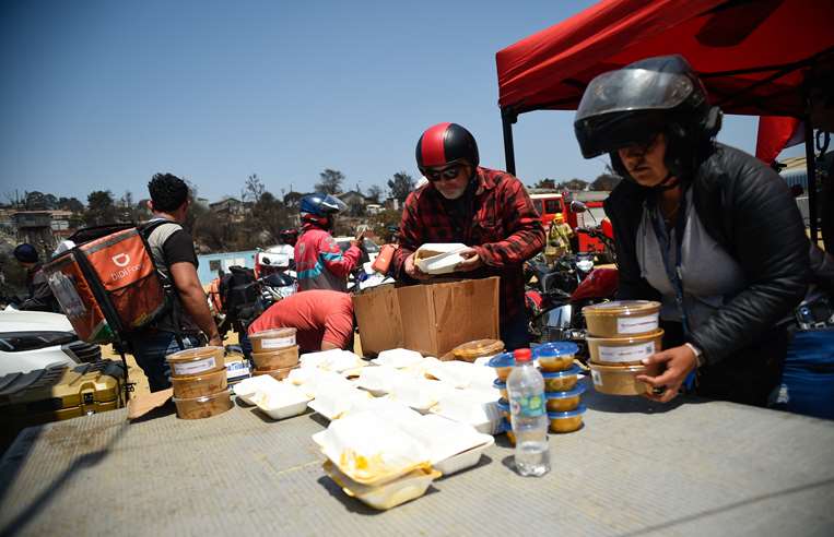 Bomberos voluntarios reciben donaciones de agua y alimentos / Foto: AFP