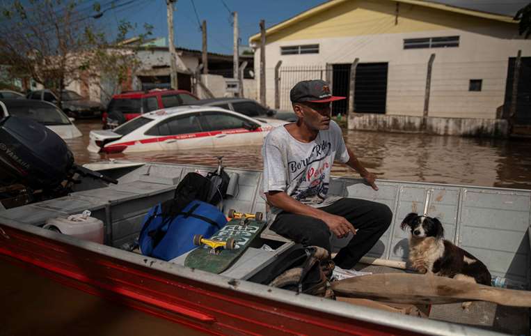 La gente intenta salvar a sus mascotas en Río Grande do Sul /Foto: AFP