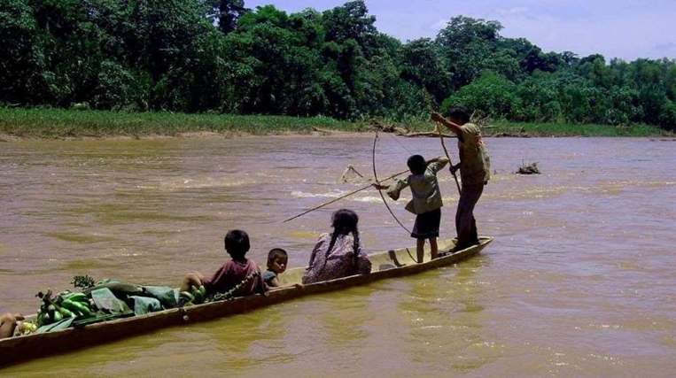 Una familia chimán casa pescado con arco y flecha, mientras se desplaza por el río
