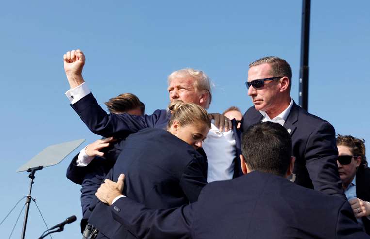 Donald Trump, visiblemente herido, es retirado por sus guardaespaldas/AFP