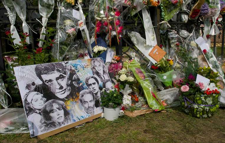 Flores y velas en las puertas de la vivienda del actor fallecido Alain Delon/ AFP